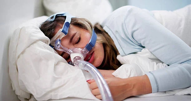 Woman sleeping Sleep on her Stomach with a CPAP Mask