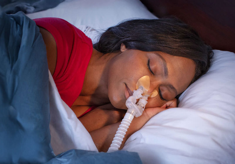 Person sleeping with a CPAP nasal mask.
